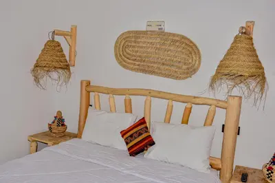 a bedroom with a bed and baskets on the wall at Hotel Safari Week end in Midelt