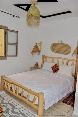 a bedroom with a wooden bed in a room at Hotel Safari Week end in Midelt