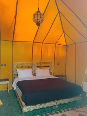a bedroom with a bed in a tent at Camp Under Stars in Merzouga