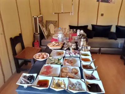 a table with many plates of food on it at Camp Under Stars in Merzouga