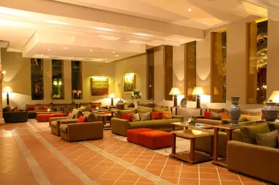 a hotel lobby with couches and tables at Berbère Palace in Ouarzazate
