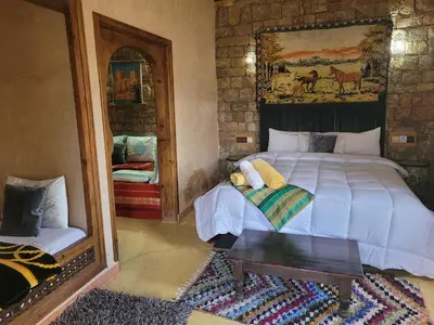 a bedroom with a large bed and a mirror at Chambre d'hôtes aya in Ouzoud