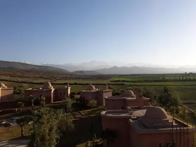 a group of domes in a desert with mountains in the background at Citadelle d'Orient in Aghmat