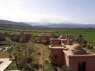 an aerial view of a village with mountains in the background at Citadelle d'Orient in Aghmat