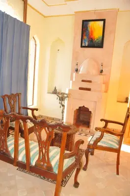 a living room with a table and chairs and a fireplace at Citadelle d'Orient in Aghmat