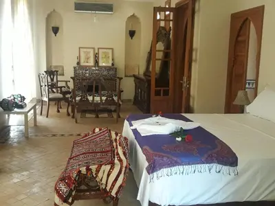 a bedroom with a bed and a dining room at Citadelle d'Orient in Aghmat