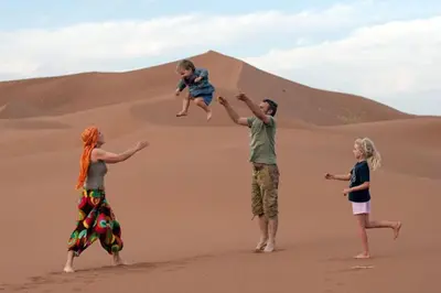 a group of people playing in the desert at M'hamid Desert Camp Tours in Mhamid
