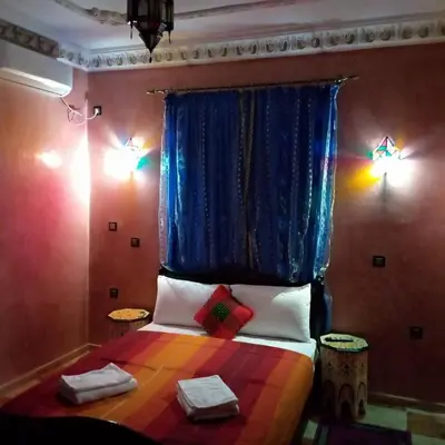 a bedroom with a colorful bed with two towels on it at Dar Marwa in Ouzoud