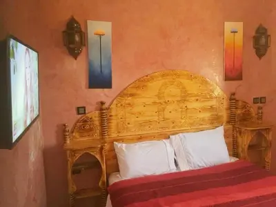 a bed with a wooden headboard in a room at Dar Marwa in Ouzoud