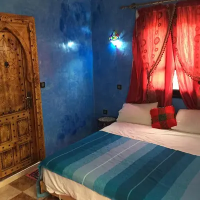 a bedroom with a bed and a window and a door at Dar Marwa in Ouzoud
