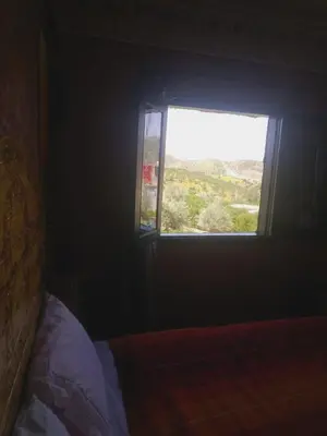 a bedroom with a bed and a window with a view at Dar Marwa in Ouzoud