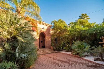 a house with a palm tree and a brick driveway at Villa Septha in Marrakech