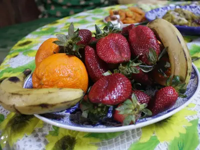 a plate of fruit on a table with bananas and strawberries at Dar Ouassim in Fès