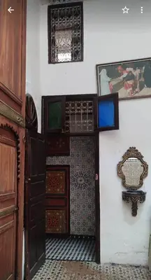 a room with a door and a wall with tiles at Dar Ouassim in Fès