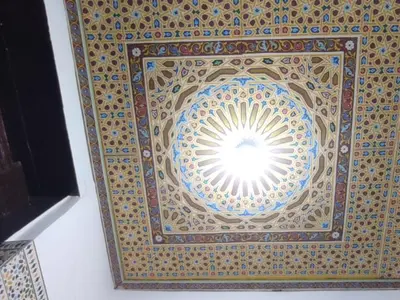 a ceiling of a building with a sun in the middle at Dar Ouassim in Fès