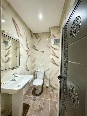 a bathroom with a white toilet and a sink at Hôtel Zaghro in Ouarzazate