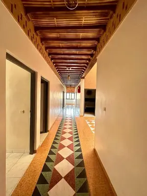 a hallway with a checkered floor in a building at Hôtel Zaghro in Ouarzazate