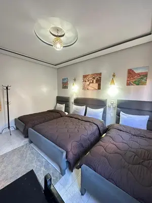 two beds sitting next to each other in a bedroom at Hôtel Zaghro in Ouarzazate