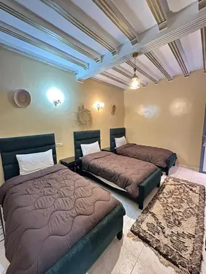 a bedroom with two beds in a room at Hôtel Zaghro in Ouarzazate