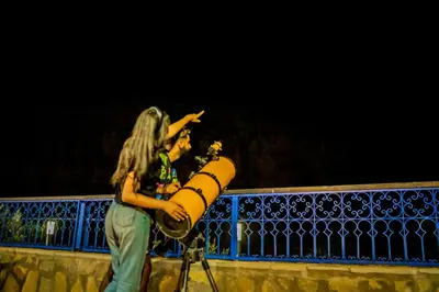two women standing in front of a fence with a cannon at Ouednoujoum Ecolodge & Spa in Ouarzazate