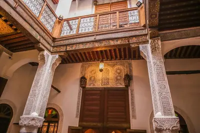 a building with a wooden door and a balcony at Riad Gzira Fez in Fès