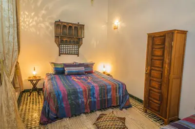 a bedroom with a bed and a dresser at Riad Gzira Fez in Fès