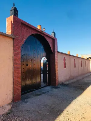 a brick building with a large wooden door at Riad Dar Bab Todra in Tinerhir