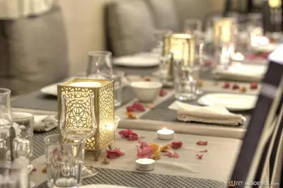 a table with plates and glasses and candles on it at Guest House Bagdad Café in Aït Ben Haddou