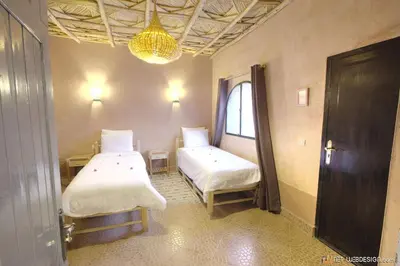 a room with two beds and a chandelier at Guest House Bagdad Café in Aït Ben Haddou