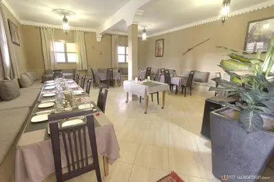 a restaurant with tables and chairs in a room at Guest House Bagdad Café in Aït Ben Haddou