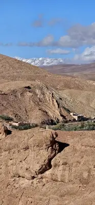 a view of a desert with snow covered mountains at Dar Essalama Dades in Akhendachou nʼAït Ouffi