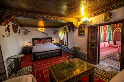 a bedroom with a bed and a table in a room at Dar Mayssae in Fès