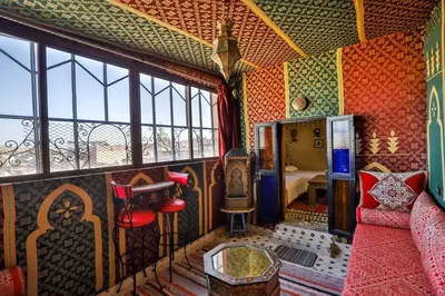 a room with a couch and a table and windows at Dar Mayssae in Fès