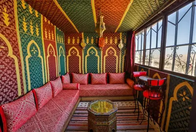 a train room with red seats and colorful walls at Dar Mayssae in Fès