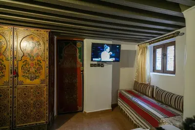 a room with a couch and a tv on a wall at Dar Mayssae in Fès