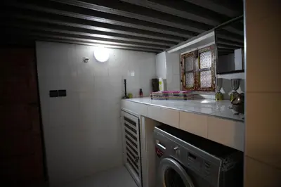 a small kitchen with a washing machine in it at Dar Mayssae in Fès