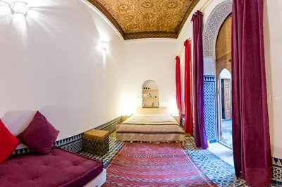 a bedroom with two beds and a couch in a room at Riad La Maison D'à Côté in Meknès