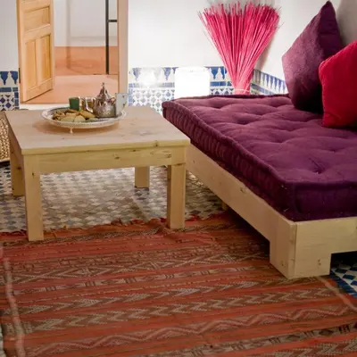 a living room with a purple couch and a table at Riad La Maison D'à Côté in Meknès