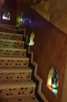 a staircase in a house with two arched windows and a stair case at Kasbah Assafar in Kalaat MGouna