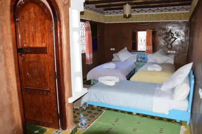 a bedroom with two beds and an open door at Kasbah Assafar in Kalaat MGouna
