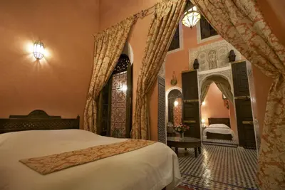 a bedroom with a large bed and a room with a bed sqor at Dar Anebar in Fès