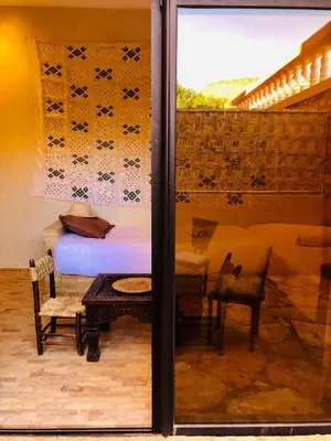 a bedroom with a bed and a table and chairs at Kasbah Isfoula and spa in Aït Ben Haddou