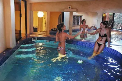 three women in a swimming pool in a hotel at Kasbah Isfoula and spa in Aït Ben Haddou