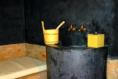 a bucket and two faucets in a bathroom at Kasbah Isfoula and spa in Aït Ben Haddou