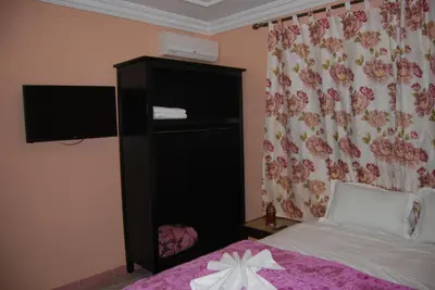 a bedroom with a bed and a flower curtain at Résidence MARWA in Ouarzazate