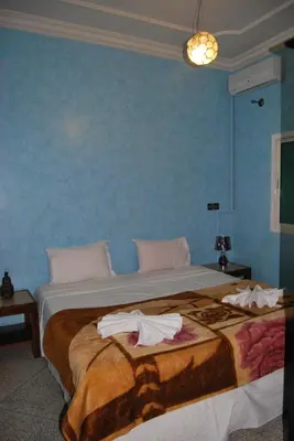 a bedroom with a large bed with towels on it at Résidence MARWA in Ouarzazate