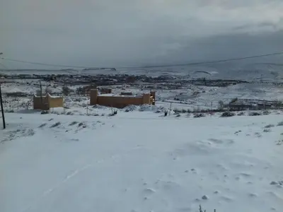 a snow covered field with a city in the distance at Kasbah Izoran in Midelt