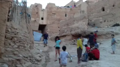 a group of people standing around a stone building at Kasbah Izoran in Midelt