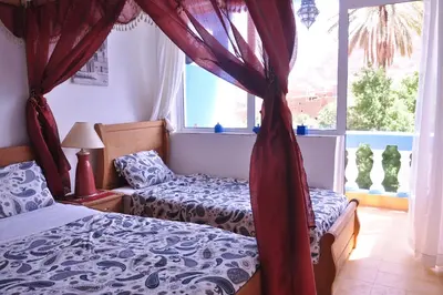 a bedroom with two beds and a window at A Secret Garden in Tinerhir