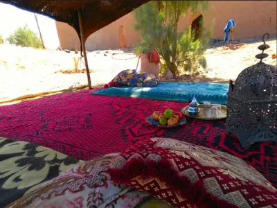 a table with fruit on a blanket on the beach at Camp Iguidi Tours in Mhamid